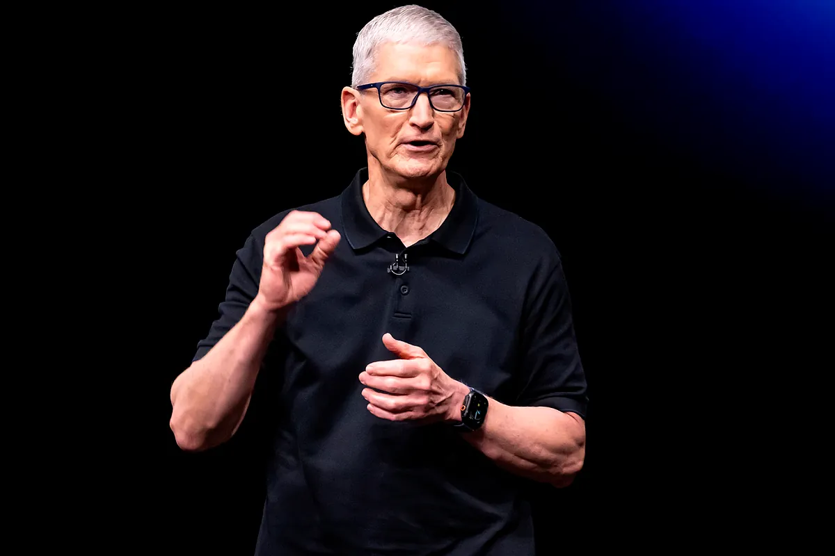 Tim Cook, CEO di Apple, durante un evento aziendale a Cupertino, con un iPhone e un tablet